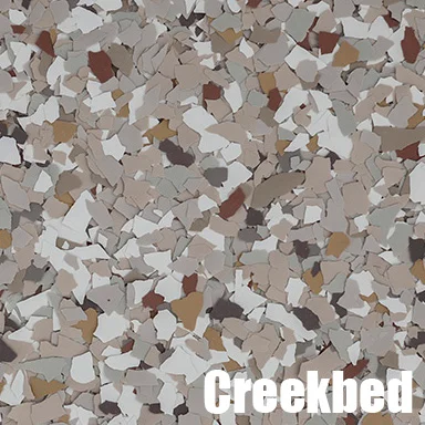 Creekbed-style epoxy floor with mixed earth-tone flakes in cream, tan, rust, and gray